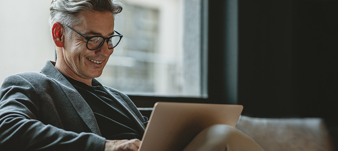 man smiling at his computer