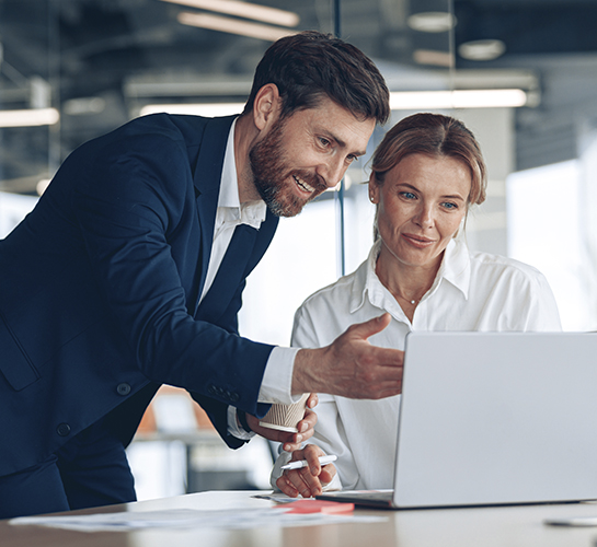 man and women at office looking at a laptop computer