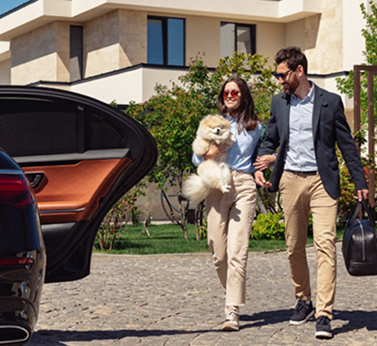 couple with their dog getting into a car