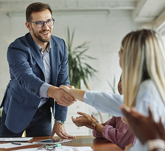 man shaking the hands of a woman at office