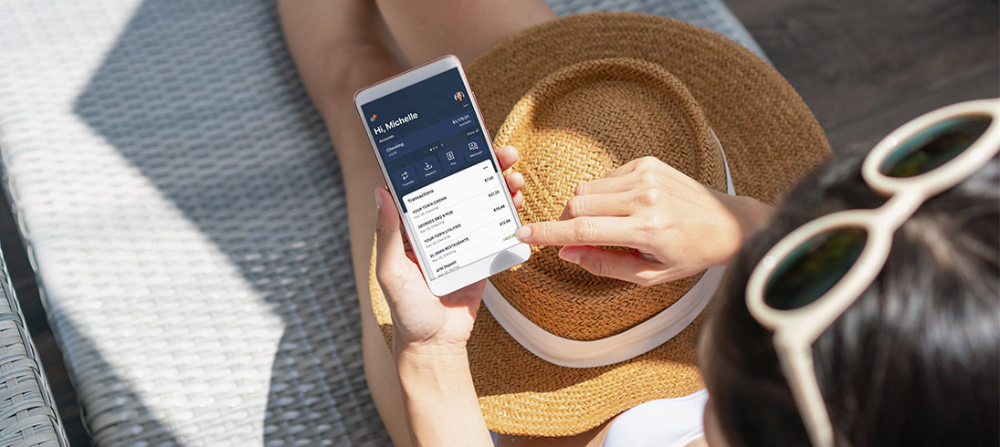 women looking at phone with her sun hat in her lap