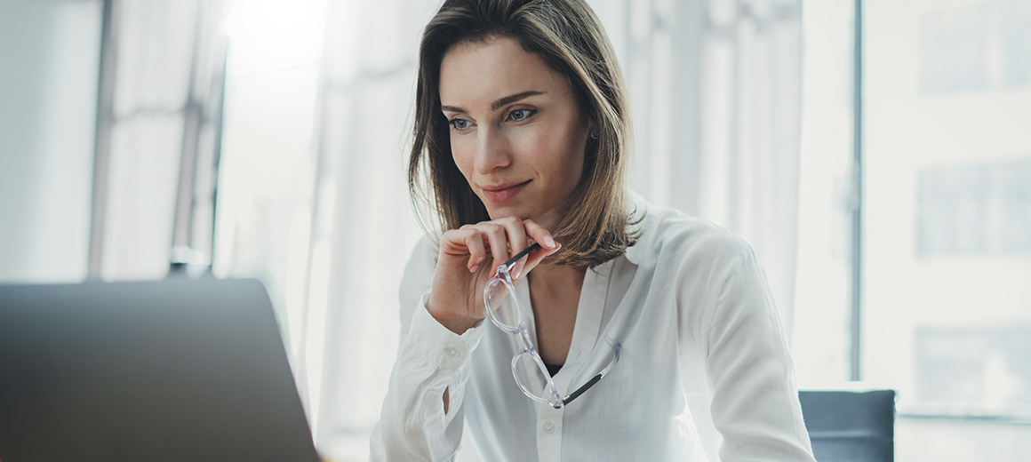women looking contemplative at laptop