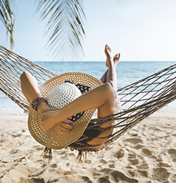 women lying in a hammock on beach