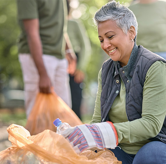 women wearing gloves picking up trash at a community event