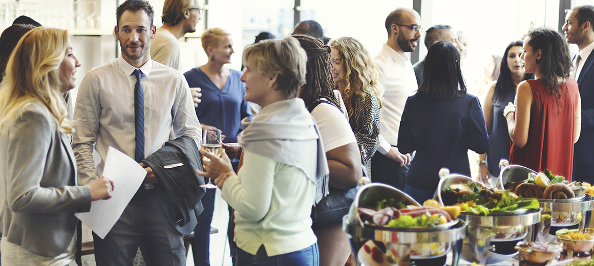 gathering of people with a table of food