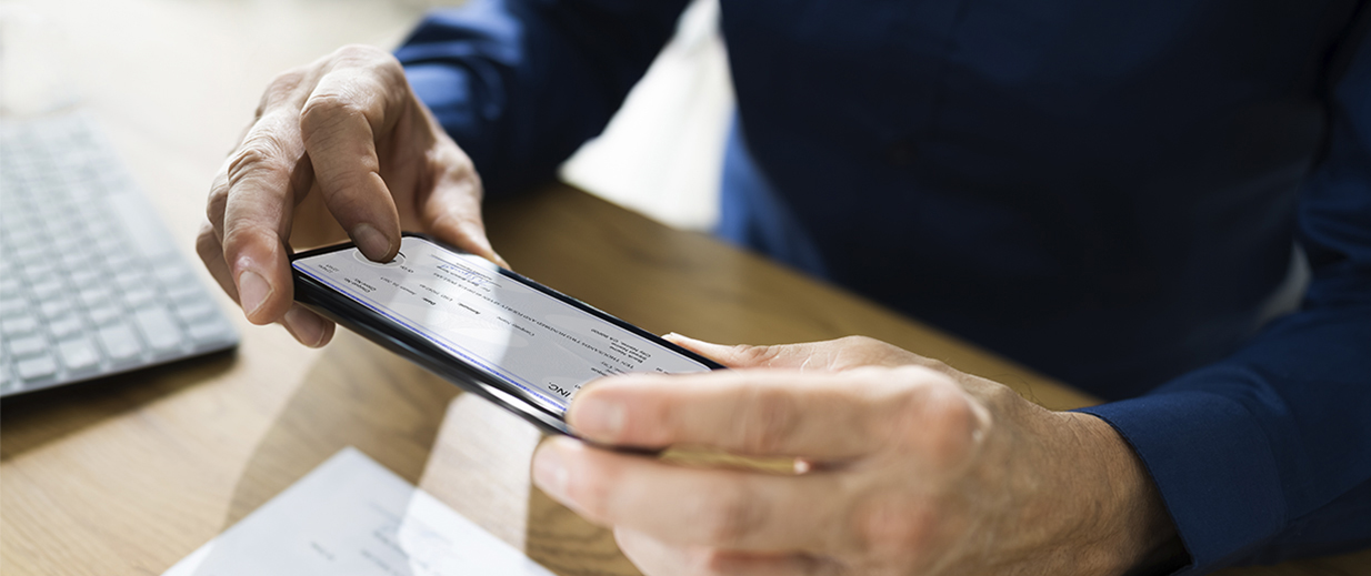 someone taking a photo of a check with their phone