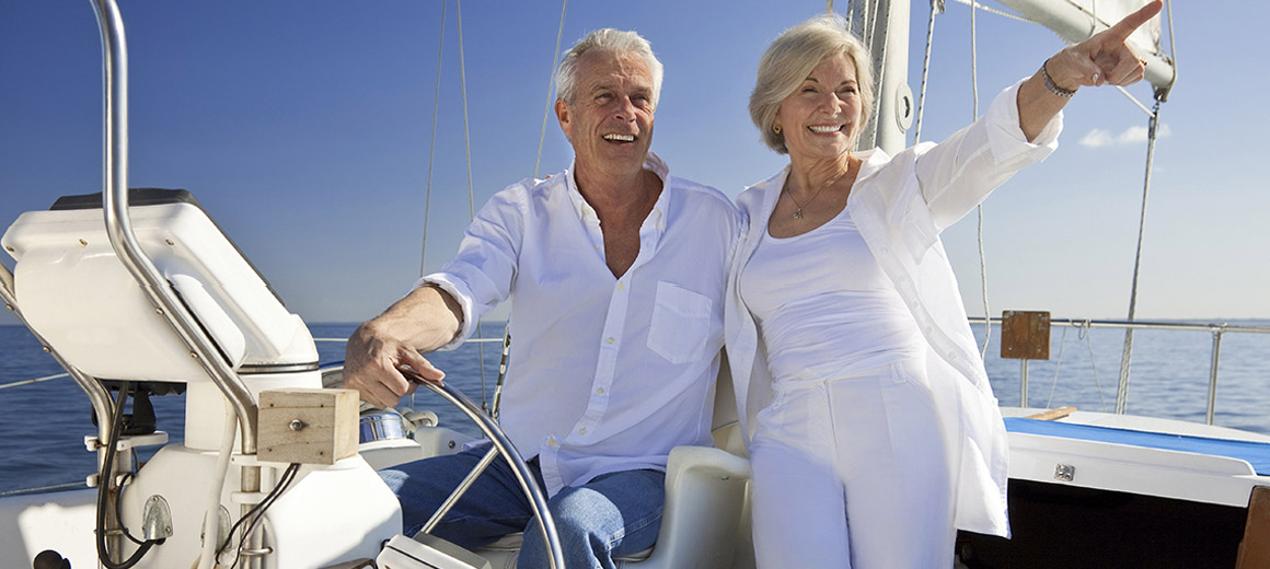 older couple on a boat pointing and smiling